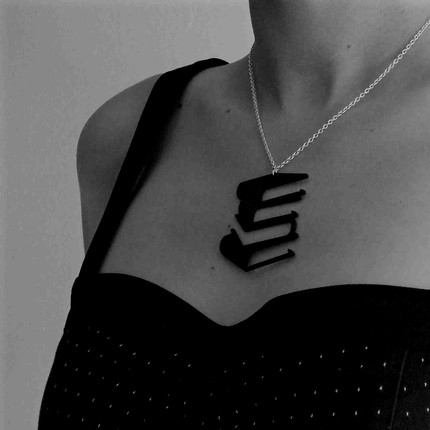 This necklace is from the Phantasmal collection. Tania Hennessy uses laser technology to cut silhouettes from reclaimed black vinyl record which results in design illusions, in this case, a stack of books.  Below are thumbnails of other designs.